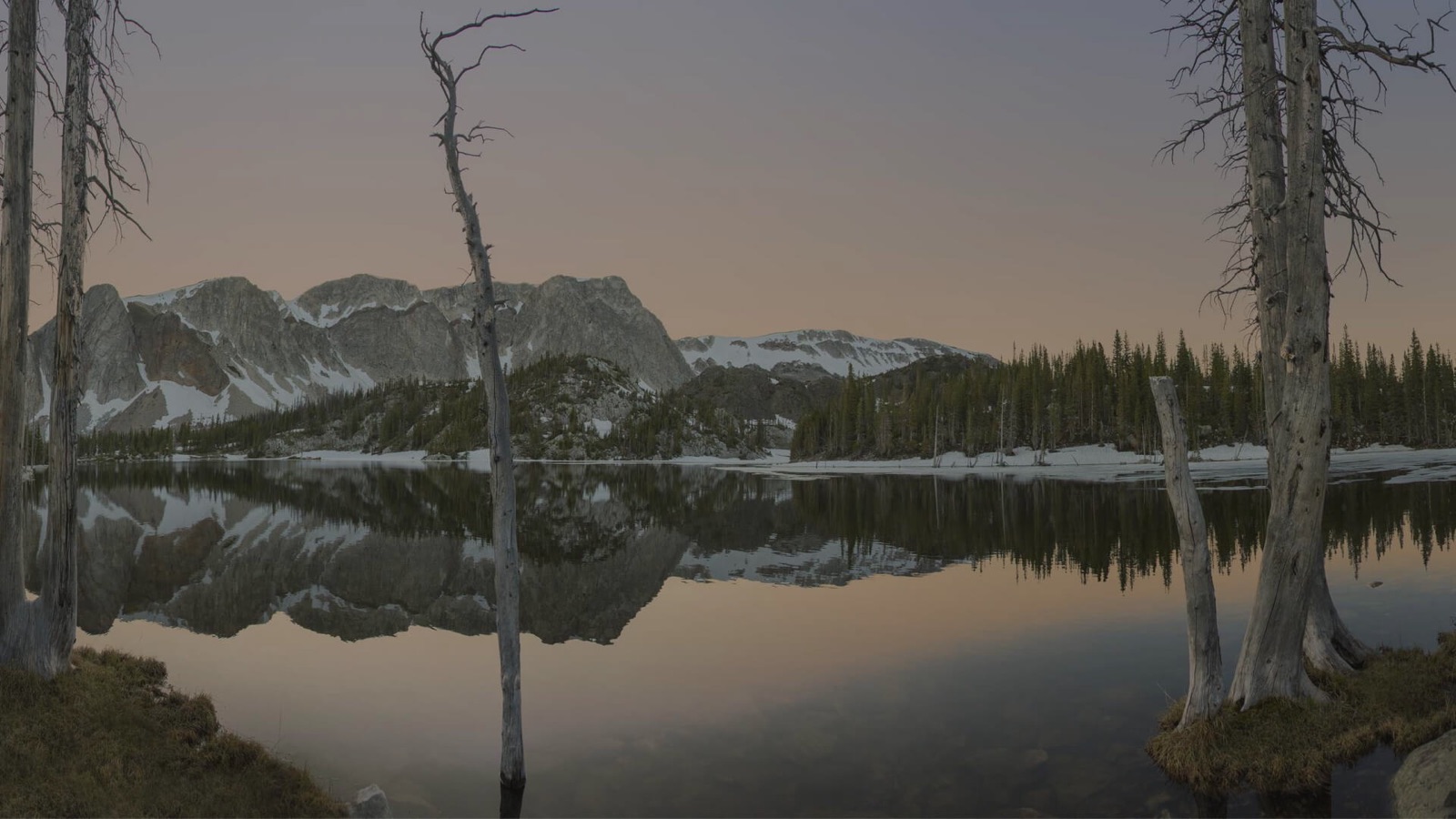 Mountains reflected in an alpine lake at dusk