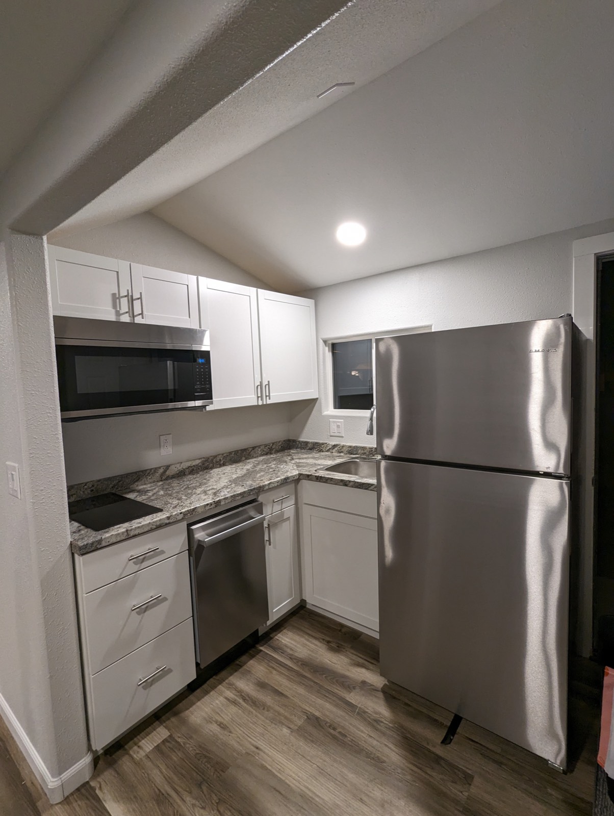 Kitchen with full-size fridge, cooktop and dishwasher in the Deluxe King Kitchenette